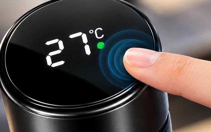 Finger touching the temperature display on the lid